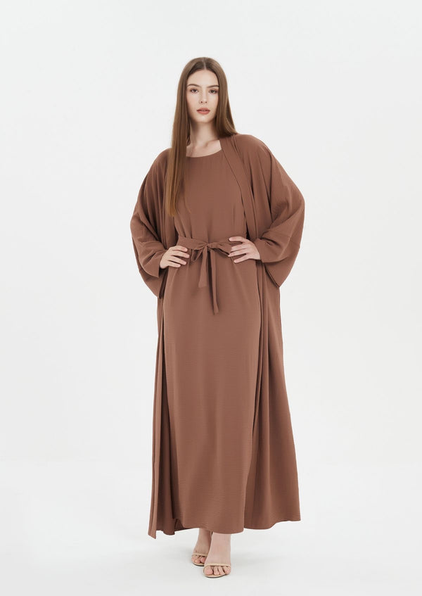 Front view of elegant brown abaya with flowing design
Close-up of sleeve detail on brown abaya