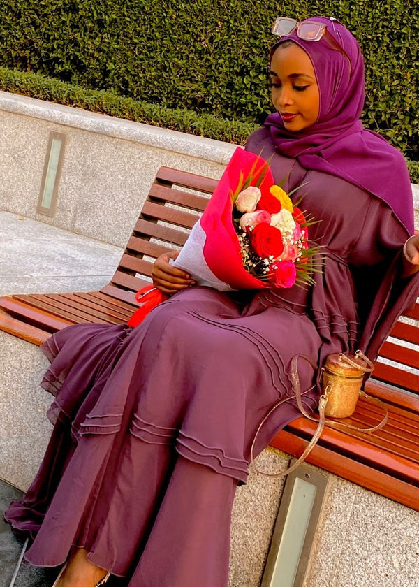 WOMEN LADIES SITTING ON BENCH SEAT IN DUBAI IN BURGUNDY RED ELEGANT FASHION ABAYA DRESS ISLAMIC DRESS HIJAB VEIL COVER MODESTY CLOTHING
